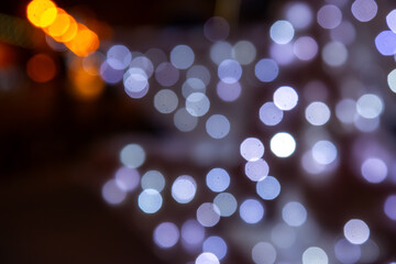 Fototapeta premium A mesmerizing bokeh effect with golden and multicolored lights on a dark background, ideal for holiday or dreamy compositions with a glow.