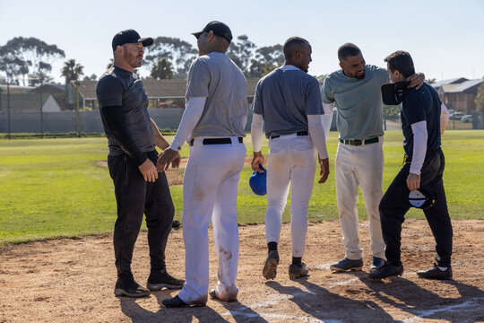 Baseball coach calling team on diamond, team consoling catcher while live stats overlaying helmets