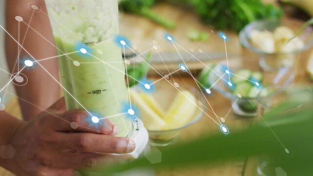 Cook pressing blender knob in kitchen, turning cucumber into green smoothie, blue node web forming