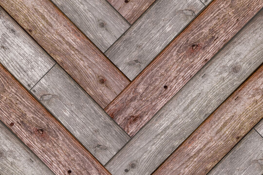 Gray and brown wood panels arranged in a herringbone pattern