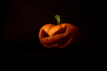 Calabaza tallada aislada en oscuridad con espacio para texto. © Oswaldo