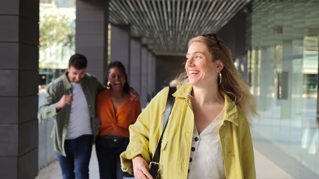 A cheerful young woman walks confidently in a vibrant urban environment, accompanied by stylish friends. Their casual outfits reflect a trendy atmosphere, capturing the essence of friendship and