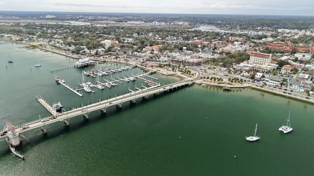 Aerial view of the Bridge of Lions and the municipal marina with sailboats moored in the Matanzas River under a clear sky in St. Augustine, Florida, United States.