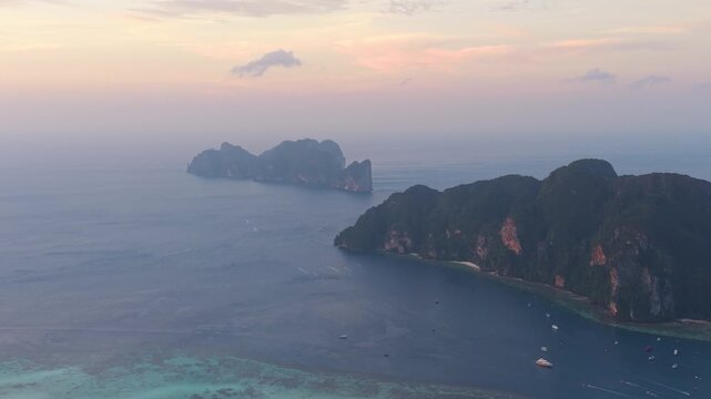 Koh Phi Phi Lee Island In Thailand At Sunset, With Steep Limestone Cliffs And Boats On Surrounding Waters. aerial shot