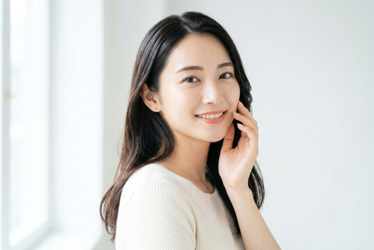 頬に手を当てて微笑む美肌の若い女性 Generative AI