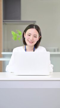 パソコンの仕事をするタイピングするオフィスカジュアルな女性の縦動画正面のイメージ