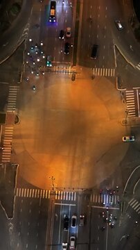 Vietnam, Da Nang Night Aerial Da Nang Intersection Asian Riders Flow Around Flashing Patrol Lights, Busy Crossroads Energy With Clustered Scooters, Buses And Illuminated Lanes