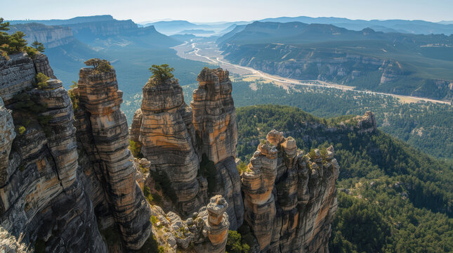 Scenic rugged sandstone pinnacles overlooking winding valley and forested mesa at golden light