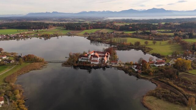Scenic view of the baroque church St. Lambert and Seeon Abbey, part of the historical ensemble in Chiemgau, Bavaria, Germany. Luftbild von Kloster Seeon und dem Seeoner See im Chiemgau in Bayern