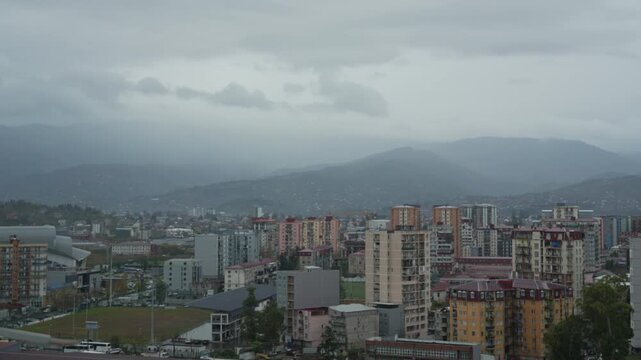 Timelapse city view near mountain, cars driving along streets, moving thunderclouds before storm. Batumi city life timelapse. Adjara, Batumi timelapse Georgia