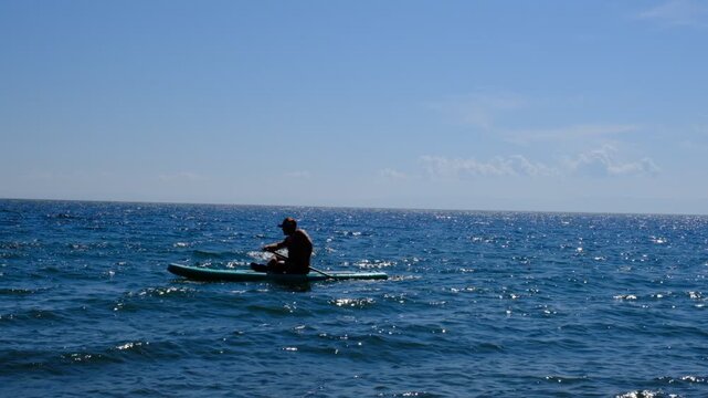 Men with sap board, swimming board. Paddleboarding. Summer leisure. Resting on the boat deck, Summer vacation on the water. Aquatic sport.	
