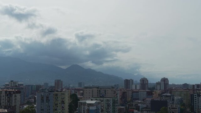 Storm warning, climate change, environmental protection. Storm clouds are scudding over a city at the foot of the Caucasus Mountains timelapse. Problem of urban air pollution