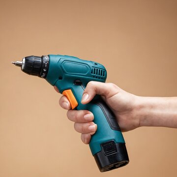 Cordless drill held by female hand in ergonomic grip against beige background