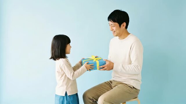 大好きなパパへ！笑顔でプレゼントを差し出す小さな女の子