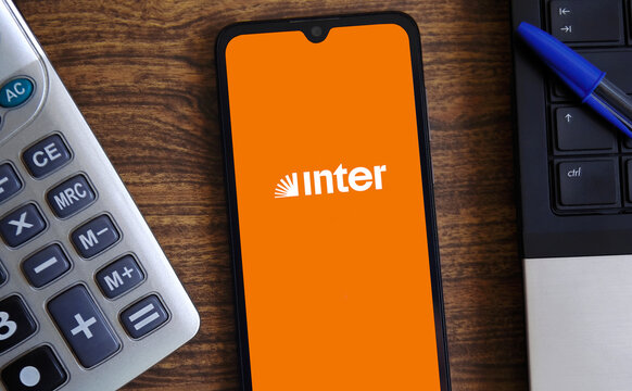 Banco Inter logo on a smartphone screen with office supplies in the background. Economics and finance concept.
