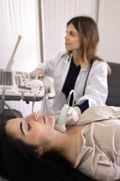 Young 30s female patient passing annual thyroid gland check-up, close up. Woman endocrinologist using ultrasound equipment, check lymph nodes during client visit in clinic. Endocrine system healthcare