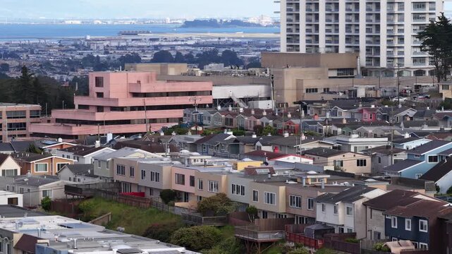 High altitude aerial drone footage over densely packed Broadmoor tract housing neighborhood in Daly City, California.
