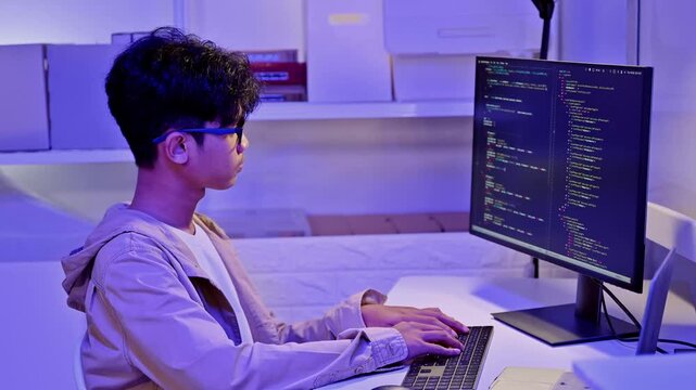 Smart IT Student Analyze Software Code On Desktop Screen In Blue Light Room