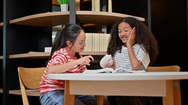 Multiethnic Young Girl Read Book And Study Together In Modern Library Room