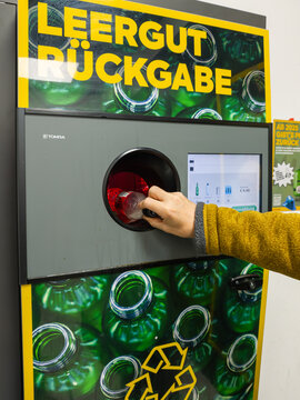 April 16, 2026, Vienna, Austria. Person inserting plastic bottle into recycling deposit return machine