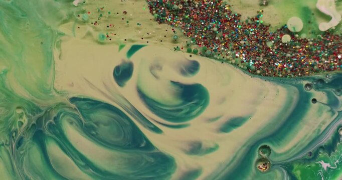 Color paint water. Sequins background. Defocused green bubble acrylic marble oil splash round texture flowing on creative art abstraction.