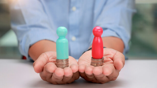 Person hands holding wooden figure on coin stack presenting hopeful diverse financial opportunities for equality and future growth