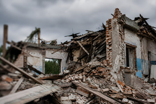 Collapsed building after earthquake disaster with destroyed residential house, rubble and structural damage under dramatic storm clouds. Natural catastrophe aftermath, urban destruction, emergency res