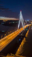 Obraz premium A nighttime aerial view of a large suspension bridge over a body of water