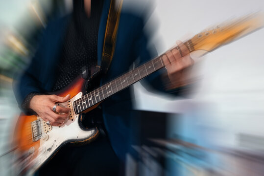 Rock band studio rehearsal. Male musician playing bass guitar before live concert with motion blur effect