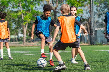 World cup concept with soccer ball or football player, youth soccer players practice on outdoor field with ball and orange and blue vest, active team sport training in sunny park © chokniti