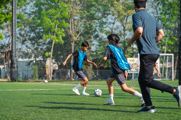 Obraz premium World cup concept with soccer ball or football player, youth soccer training on outdoor field with coach and players in practice