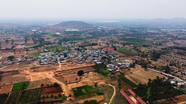Kuduvathi village with farming land, hills and road near nandi hills at karnataka, india. day time, circle shot, drone shot, 4k.