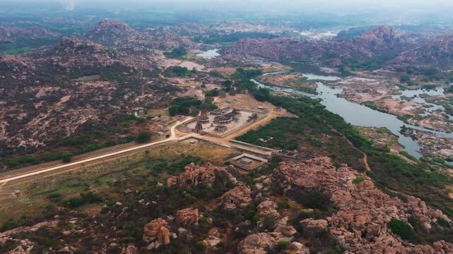 Maha Mantapa with musical pillars, Vitthal Mandirv, The Stone Chariot, rocky terrain and Tungabhadra river at nimbapura, hampi, karnataka, india. day time, semi orbit shot, zoom in, drone shot, 4k.