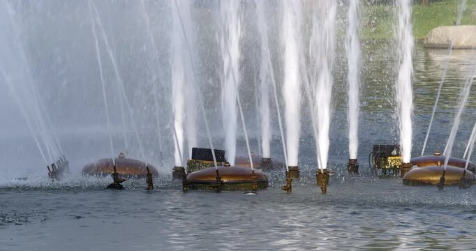 A vibrant fountain performance where dancers interact with water jets in a lively city park.