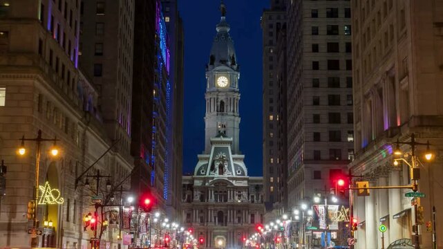 Night time lapse of philadelphia city hall view from broad street with moving traffic and changing building lights showing urban motion and street life.