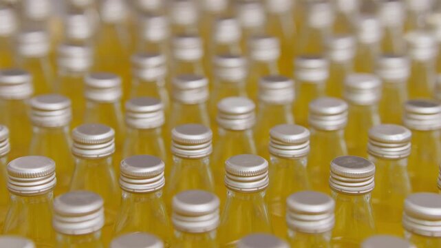 Bottled Refreshments in Formation: A sea of uniform bottles, filled with a vibrant, refreshing drink, lines up in perfect order, ready for consumption.
