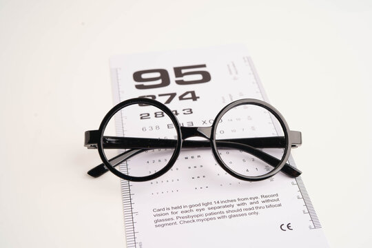 Glasses on eye testing exam chart to check eyesight accuracy of reading.