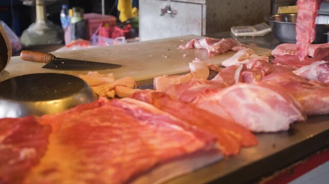 Market counter with freshly chopped meat pieces tools and cutting surface after preparation. Meat processing concept
