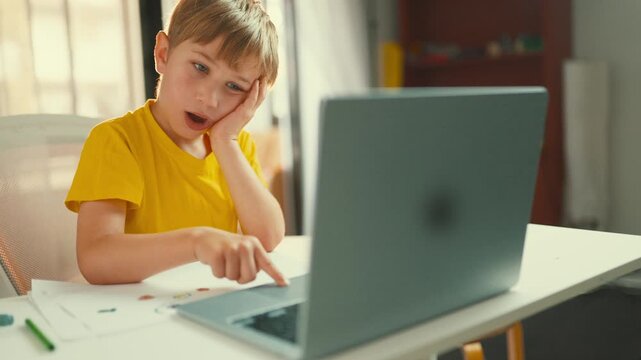 Bored tired boy yawning during online class homework