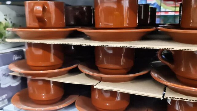 Sidosrjo, Indonesia - 4 May, 2026: Brown Ceramic Coffee Cups and Saucers Stacked on Retail Supermarket Shelf