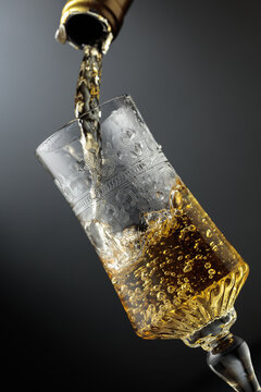 White sparkling wine is poured from a bottle into a glass.
