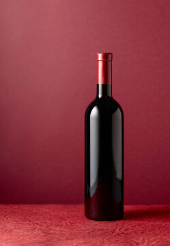 Bottle of red wine on a red background.