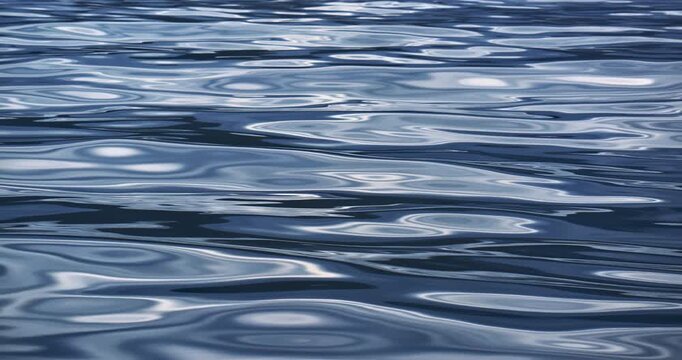 Abstract blue water surface with smooth ripples and bright reflections Calm liquid texture with glossy highlights soft wave patterns and peaceful nature background for wellness design and marine theme