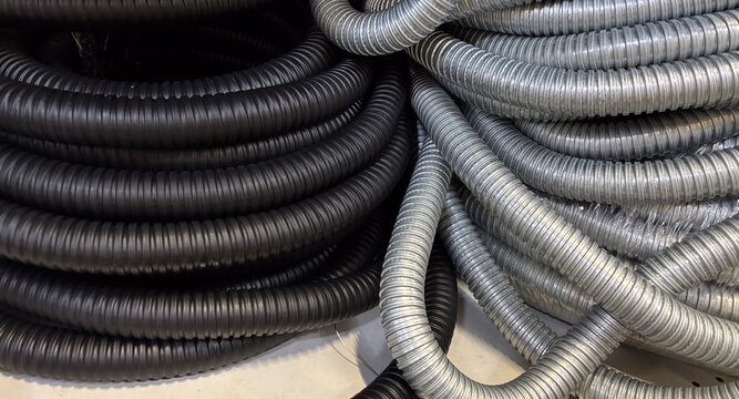 Close up of black and gray flexible corrugated hoses for industrial or plumbing protection