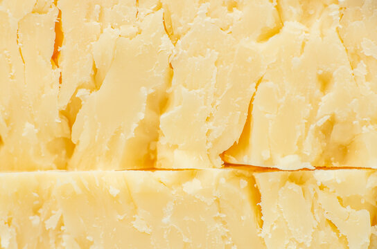 Aged parmesan cheese texture background close up