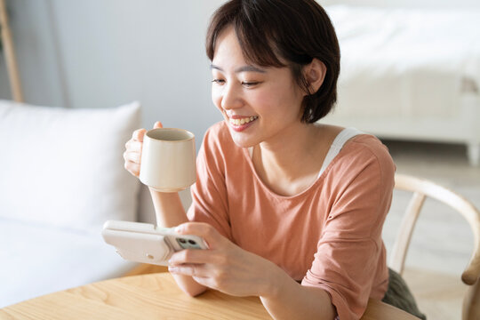 家でスマホで動画鑑賞をしているショートカットの女性
