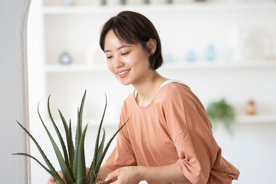 アロエの鉢を持っているショートカットの女性