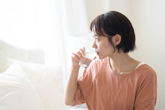 グラスに入った水を飲んでいるショートカットの女性