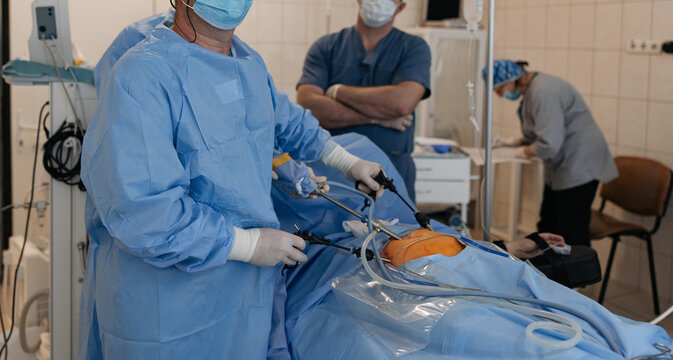 Surgeons performing laparoscopic abdominal surgery with endoscopic tools