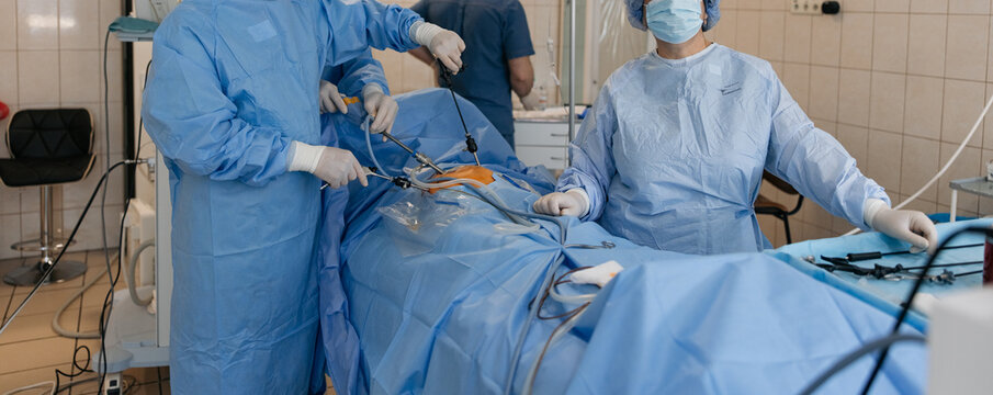 Surgeons performing laparoscopic abdominal surgery with endoscopic tools